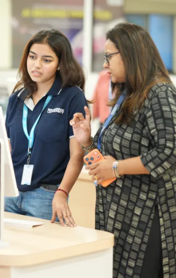 Faculty mentor guiding a student at the Fund Manager AI demo